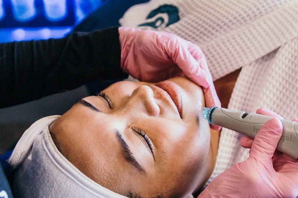 Medical Professional at Restore provides Hydrafacial Therapy to a woman