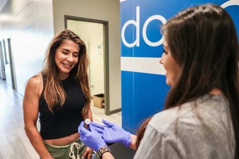 Medial professional explains to a woman what to expect from IV DRIP therapy at Restore Hyper Wellness