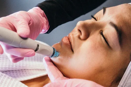 A woman with closed eyes during hydrafacial tretment at Restore Hyper Wellness