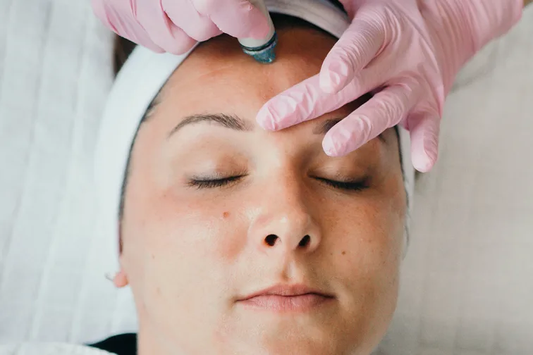 a woman getting a hydra facial.