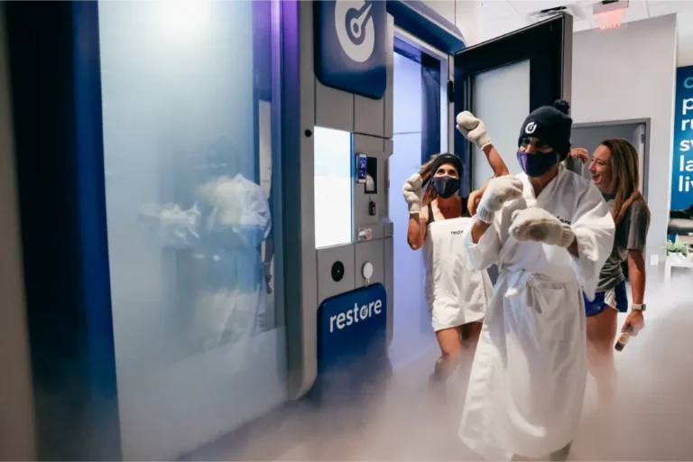 2 people with gloves leaving a cryotherapy chamber.