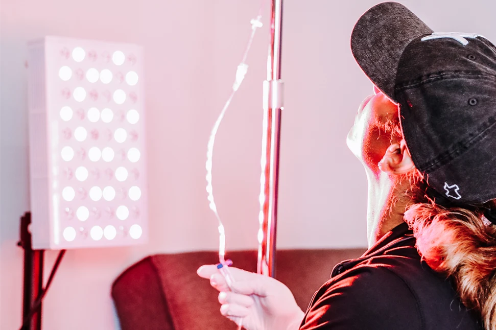 Woman with baseball cap preparing an IV drip.