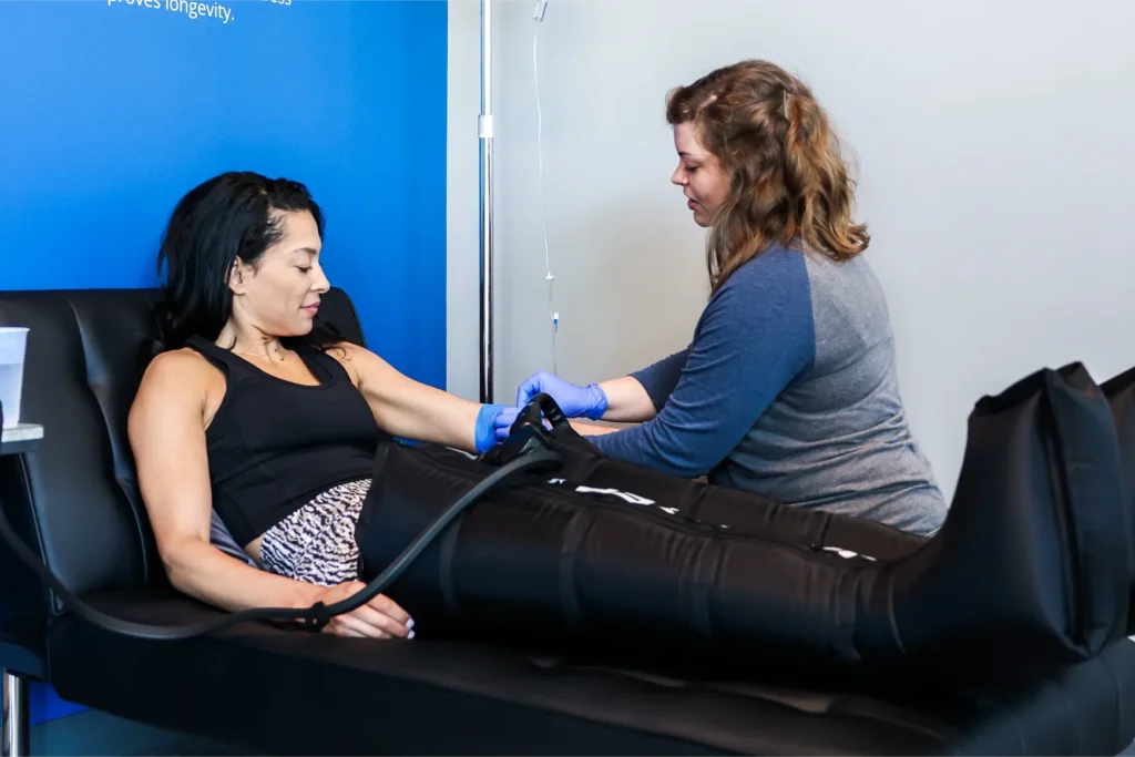 A woman getting an IV Drip nad also getting compression therapy at the same time.